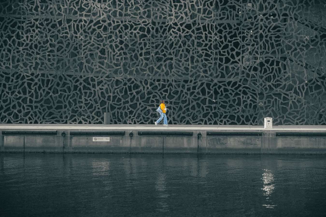 Promeneur devant une façade du Mucem